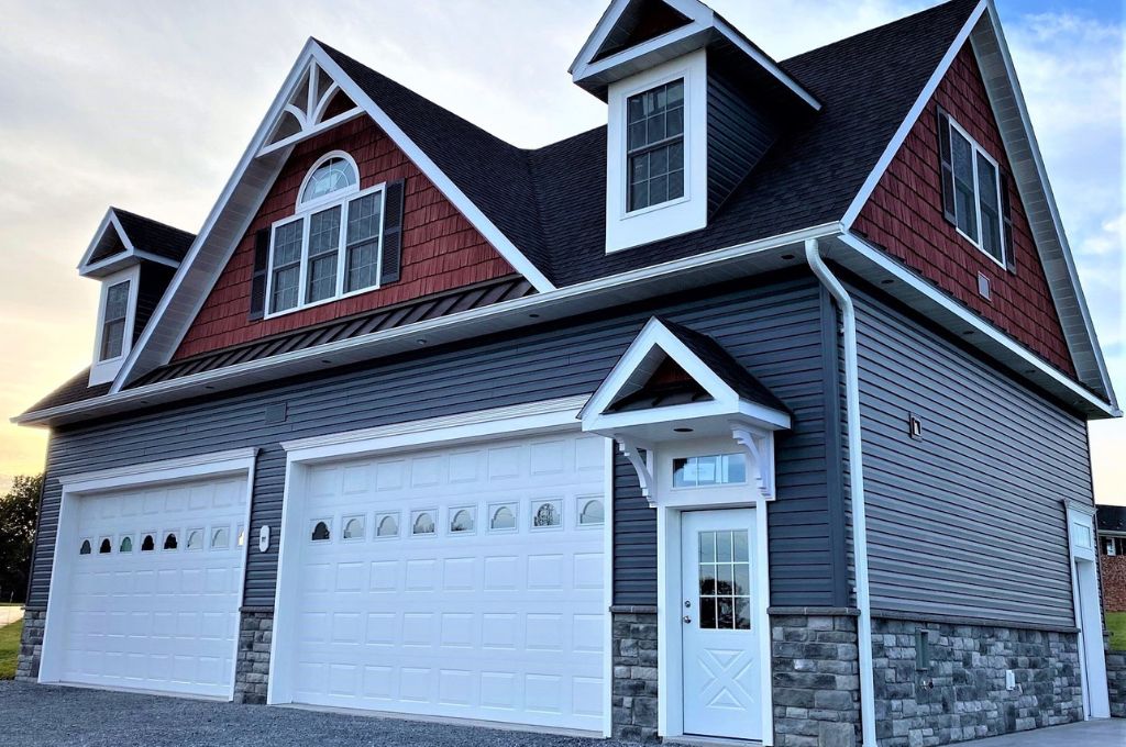 2-car custom detached garage types with white doors, gray and blue vinyl siding, and an asphalt shingle roof